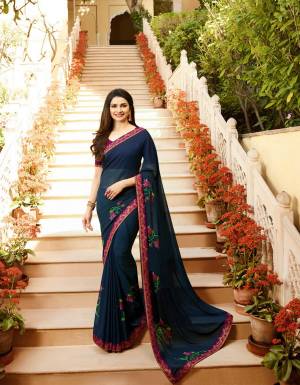 Enhance Your Personality Wearing This Casual Saree In Navy Blue Color Paired With Contrasting Magenta Pink Colored Blouse. This Saree Is Fabricated On Georgette Paired With Art Silk Fabricated Blouse. It Is Beautified With Multi Colored Floral Prints. 
