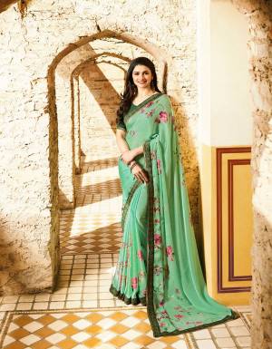 A Very Pretty Shade In Green Is Here With This Saree In Sea Green Color Paired With Green Colored Blouse. This Saree Is Fabricated On Georgette Paired With Art Silk Fabricated Blouse. This Saree Is Beautified With Contrasting Colored Floral Prints All Over. Buy Now.