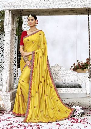 Celebrate This Festive Season Wearing This Designer Attractive Saree In Yellow Color Paired With Contrasting Red Colored Blouse. This Saree Is Fabricated On Soft Silk Paired With Art Silk Fabricated Blouse. It Is Beautified With Embroidered Motifs And Lace Border.