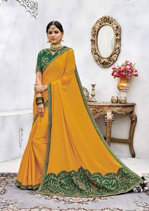 Celebrate This Festive Season Wearing This Designer Attractive Saree In Musturd Yellow Color Paired With Contrasting Green Colored Blouse. This Saree Is Fabricated On Soft Silk Paired With Art Silk Fabricated Blouse. It Is Beautified With Embroidered Motifs And Lace Border.