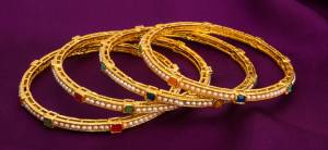 Go Trendy With This Pretty Bangle Set In Golden color Beautified With Moti And Stone Work. This Heavy Looking Bangle Set Is Light Weight And Easy To Carry All Day Long.