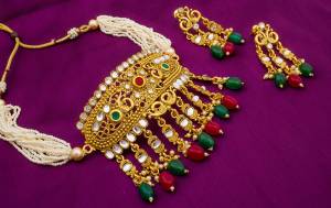 For A Queen Look, Grab This Beautiful And Heavy Necklace Set In Golden Color Beautified With Multi Coloreed Stone Work. It Can Be Paired With Any Ethnic Attire, Be It A Silk Saree, Lehenga Or Suit.