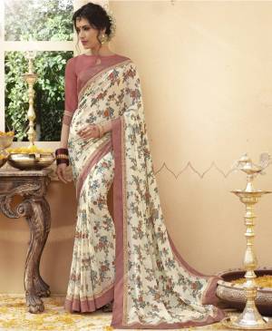 Here Is A Very Pretty Saree In Off-White Color Which Will Earn You Lots Of Compliments From Onlookers, It Is Paired With Dusty Pink Colored Blouse. This Saree And Blouse Are Fabricated On Georgette Beautified With Floral Prints All Over It. Buy Now.