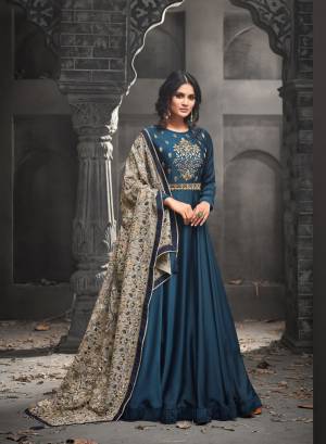 Add This New Shade To Your Wardrobe With This Designer Floor Length Suit In Teal Blue Color Paired With Teal Blue Colored Bottom And Contrasting Grey Colored Dupatta. Its Top Is Fabricated On Satin Silk Paired With Santoon Bottom And Georgette Dupatta. It Is Beautified With Attractive Embroidery Over The Yoke And All Over The Dupatta. Buy This Designer Suit Now.