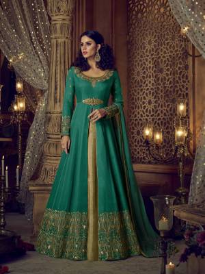 Bright And Visually Appealing Color Is Here With This Semi-Stitched Suit In Green Colored Heavy Designer Floor Length Suit Paired With Green Colored Pants And Golden Colored Skirt And Green And Colored Dupatta. Its Top, Pants And Skirt Are Fabricated On Art Silk Paired With Net Fabricated Dupatta. This Bright Semi-Stitched Is Beautified With Heavy Embroidery Over The Top And Pants.