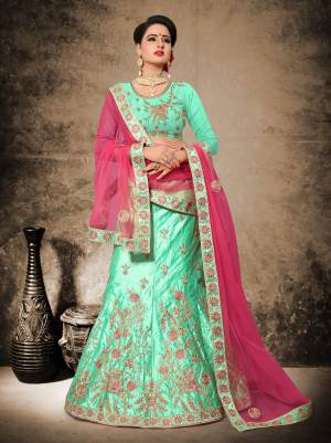 Add This Lovely Shade In Green To Your Wardrobe With This Heavy Designer Lehenga Choli In Sea Green Color Paired With Contrasting Rani Pink Colored Dupatta. Its Blouse And Lehenga Are Fabricated On Velvet Satin Paired With Net Fabricated Dupatta. 