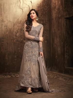 Here Is A Designer Suit With Fish Tail Pattern In Grey Colored Top Paired With Grey Colored Bottom And Dupatta. Its Top Is Fabricated On Net Paired With Jacquard Net And Santoon Bottom And Chiffon Dupatta. Also This Suit Is Beautified With Heavy Embroidery Which Gives An Attractive Look.