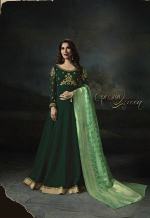 Here Is An Attractive Designer Floor Length Suit In Dark Green Color Paired With Dark Green Colored Bottom And Green Colored Dupatta. Ita Top Is Fabricated On Georgette Paired With Santoon Bottom And Banarasi Art Silk Dupatta. It Is Beautified With Embroidery Over The Yoke And Sleeves. Buy Now.
