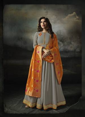 Flaunt Your Rich And Elegant Taste Wearing This Designer Floor Length Suit In Grey Color Paired With Grey Colored Bottom And Orange Colored Dupatta. Its Top Is Fabricated On Georgette Paired With Santoon Bottom And Banarasi Art Silk Dupatta. It Has Contrasting Elegant Embroidery Which Will Earn You Lots Of Compliemnts From Onlookers.