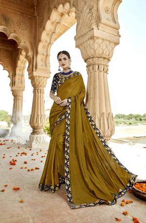 New And Unique Shade Is Here To All Into Your Wardrobe With This Designer Saree In Olive Green Color Paired With Contrasting Navy Blue Colored Blouse. This Saree And Blouse Are Fabricated On Art Silk Beautified With Embroidered Lace Border And Blouse. Buy This Saree Now.