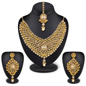 Here Is A Heavy Necklace Set To Pair Up With Your Heavy Ethnic Dress Such As Heavy Lehenga Or Floor Length Suit. This Set Is Also Suitable For Bridal Wear. It Is In Golden Color Beautified With White And Yellow Colored Stones, Buy Now.
