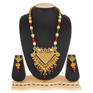 For A Royal Heavy Look, Grab This Beautiful Necklace Set In Golden Color Beautified With Multi Colored Stone Work. This Necklace Set Can Be Paired With Any Contrasting Colored Attire And Best Suits On Silk Saree.