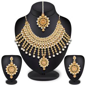 To Give A Heavy And Enhanced Look, Grab This Beautiful Necklace Set Beautified With Stones And Pearls. It Comes With A Pair Of Earrings And Maang Tika. This Can Be Paired With Any Colored Traditional Attire. Buy Now.