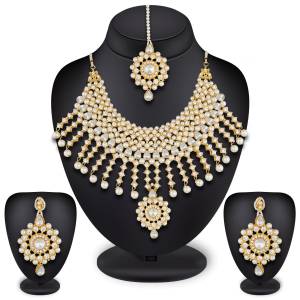 To Give A Heavy And Enhanced Look, Grab This Beautiful Necklace Set Beautified With Stones And Pearls. It Comes With A Pair Of Earrings And Maang Tika. This Can Be Paired With Any Colored Traditional Attire. Buy Now.