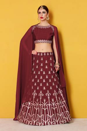 Featuring a maroon blouse in art silk with silver gold embroidery and it comes along with maroon lehenga in art silk. It is paired with maroon plain dupatta in Georgette