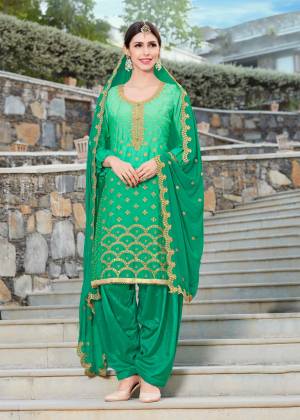 Grab This Beautiful Semi-Stitched Suit In Green Color Paired With Green Colored Bottom And Dupatta. Its Top Is Fabricated On Soft Silk Paired With Santoon Bottom And Chiffon Dupatta. Its Top And Dupatta Are Beautified With Jari Embroidery And Stone Work. Buy Now.