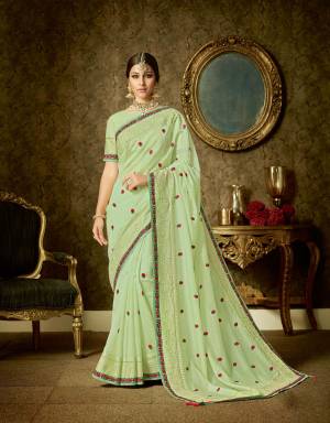 Personify your vivacious self in this beautiful and bright light green organza saree adorned with red flowers. Opt for a minimal look by matching it with subtle jewels. 