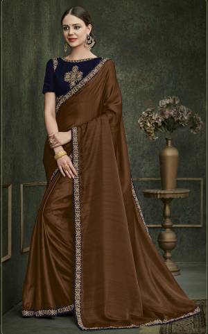 You Will Definitely Earn Lots Of Compliments Wearing This Designer Saree In Brown Color Paired With Contrasting Navy Blue Colored Blouse. This Saree Is Fabricated On Art Silk Paired With Velvet Fabricated Blouse. It Has Heavy Embroidered Blouse And Elegant Lace Border Over The Saree Gives A Rich Look Like Never Before.