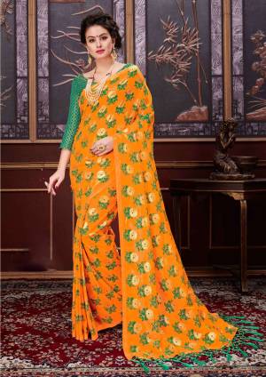 Celebrate this Festive season with attractive colors like this saree in orange color paired with contrasting green colored blouse. This saree is net based fabric paired with jacquard slk fabricated blouse.