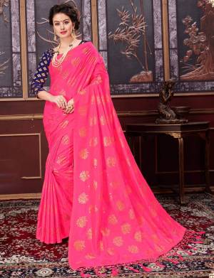 Look pretty in this bright fuschia pink colored saree paired with contrasting navy blue colored blouse. This saree is silk based fabric which gives a rich look like never before. Buy now.