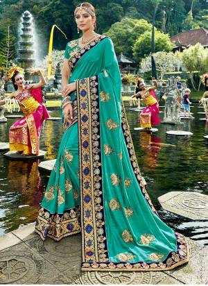 Earn lots of compliments wearing this designer saree in turquoise blue color paired with turquoise blue colored blouse. This saree and blouse are fabricated on art silk beautified with heavy embroidered lace border and embroidered motifs.