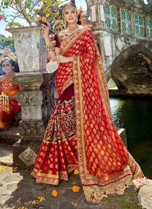 For a royal queen like look, grab this heavy designer saree in red and maroon color paired with maroon colored blouse. This saree is fabricated on georgette jacquard and art silk paired with art silk fabricated blouse. Buy this designer saree now.