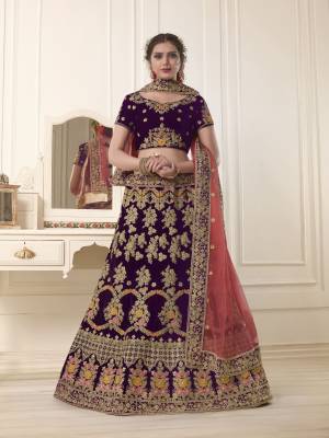 Get Ready for the upcoming wedding season with this very beautiful heavy designer lehenga choli in purple color paired ith contrasting peach colored dupatta. Its blouse and lehenga are fabricated on velvet paired with net fabricated dupatta. It Is Beautified With Heavy Embroidery All Over.