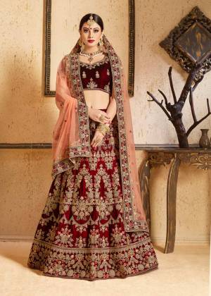 Get Ready For Your D-day With This Heavy Designer Bridal Lehenga choli In Maroon Color Paired With Contrasting Peach Colored Dupatta. This Velvet Based Lehenga And Choli Are Beautified With Heavy Jari And Resham Embroidery With Stone Work. Its Soft Net Dupatta Can Be Drape As Per It Is Suitable To You. Its Fabric Also Ensures Superb Comfort Throughout The Gala And Earn You Lots Of Compliments From Onlookers. Buy Now.