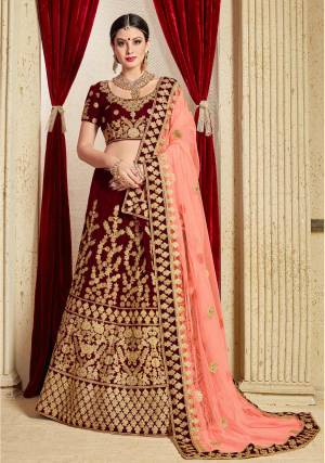 Get Ready For Your D-day With This Heavy Designer Bridal Lehenga choli In Maroon Color Paired With Contrasting Peach Colored Dupatta. This Velvet Based Lehenga And Choli Are Beautified With Heavy Jari And Resham Embroidery With Stone Work. Its Soft Net Dupatta Can Be Drape As Per It Is Suitable To You. Its Fabric Also Ensures Superb Comfort Throughout The Gala And Earn You Lots Of Compliments From Onlookers. Buy Now.