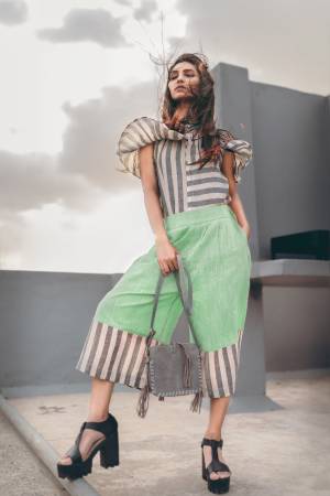Light Green khadi calf length pant with black and white strip pannel, it has front pockets as well as back pockets
Paired With Grey & white strip off shoulder top with frill pattern