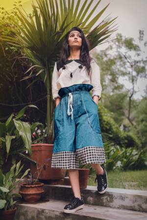 Blue khadi high waist calf length pant with full elastic at the waist 
Paired With off white top with black yoke embellished with dimond patch and teassel
sleeves - 3/4th sleeves with mid cut patern
