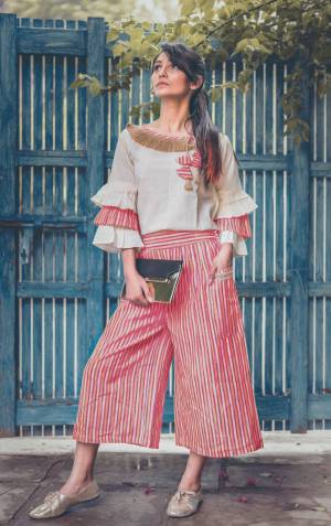 Pink linning khadi calf length pant with two big outer pocket packed with jute lace Paired With  off white pagoda sleeves top embellished jute lace at the neck line and hangging teassel