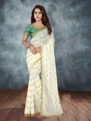 Have A Rich And Elegant Look Wearing This Designer Saree In Off-White Color Paired With Green Colored Blouse. This Saree IS Fabricated On Georgette Paired With Art Silk Fabricated Blouse.  It Has Heavy Embroidered Lace Border Over The Saree. 