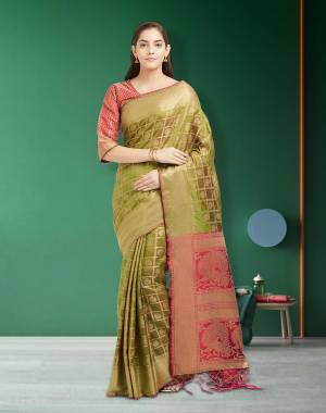 New And Unique Shade In Green Is Here With this Designer Silk Saree In Olive Green color Paired With Contrasting Red colored Blouse. This Saree And Blouse are Fabricated On Art Silk Beautified With Weave All Over. 