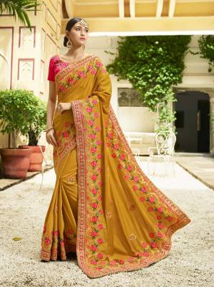 Celebrate This Festive Season Wearing this Heavy Designer Saree In Musturd Yellow Color Paired With Paired With Contrasting Dark Pink Colored Blouse. It Is Fabricated On Soft silk Beautified With Contrasting Floral Embroidery Over The Saree.