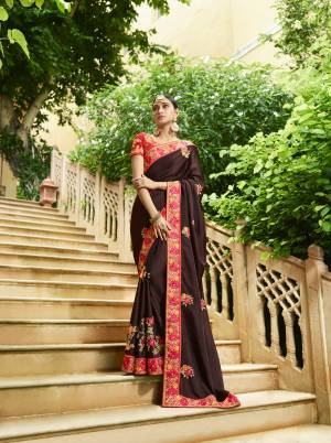 Enhance Your Personality Wearing This Designer Saree In Dark Brown Color Paired With Contrasting Red Colored Blouse. This Saree And Blouse are Silk Based Fabric Beautified With Attractive Embroidery All Over. Buy Now.