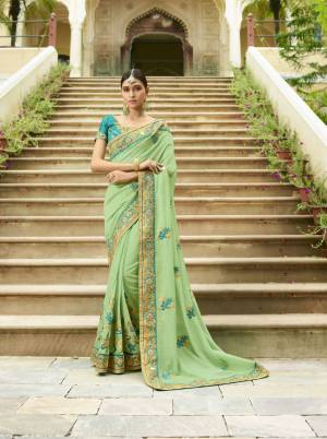 This Season Is About Subtle Shades And Pastel Play, So Grab This Pretty Designer Saree In Pastel Green Color Paired With Contrasting Turquoise Blue Colored Blouse. It IS Silk Based Which Also Gives An Elegant And Rich Look.