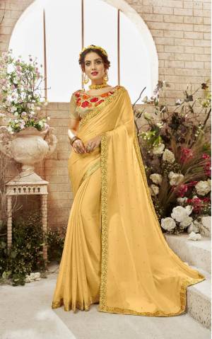 Celebrate This Festive Season Wearing This Designer Saree In Yellow Color Paired With Beige Colored Blouse. This Saree Is Fabricated On Chiffon Paired With Art Silk Fabricated Blouse. It Has Contrasting Embroidery Over The Blouse And Making It Attractive.