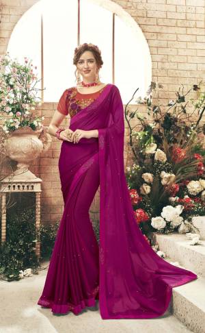 Another Dark Shade Is Here With This Designer Saree In Magenta Pink Color Paired With Contrasting Red Colored Blouse. This Saree Is Fabricated On Chiffon Paired With Art Silk Fabricated Blouse. Buy Now.