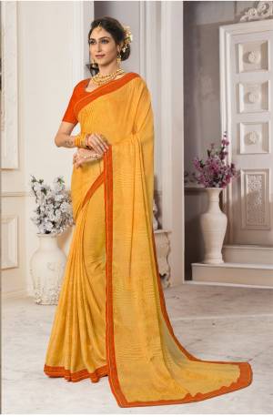 Celebrate This Festive Season Wearing This Attractive Yellow Colored Saree Paired With Contrasting Orange Colored Blouse. This Saree Is Fabricated On Georgette Chiffon Paired With Art Silk Fabricated Blouse. It Has Stone Work Over The Blouse And Saree Lace Border.