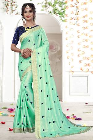 Add This Very Pretty Designer Saree In Aqua Blue Color Paired With Contrasting Navy Blue Colored Blouse. This Saree Is Fabricated On Shimmer Georgette Paired With Brocade Fabricated Blouse. It  Is Beautified With Jari And Resham Embroidery. Buy Now.