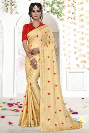 Shine Bright Wearing This Designer Saree In Beige Color Paired With Contrasting Red Colored Blouse. This Saree Is Shimmer Georgette Based Fabric Paired With Brocade Fabricated Blouse. Its Pretty Elegant Embroidery Will Earn You Lots Of Compliments From Onlookers.