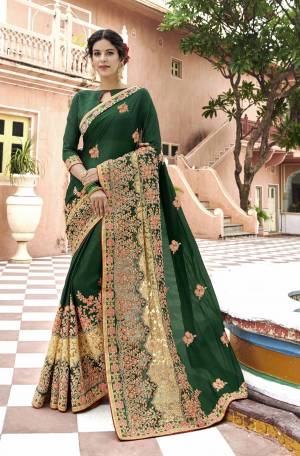 Attract All Wearing This Designer Bright Saree In Dark Green Color Paired With Dark Green Colored blouse. This Saree Is Fabricated On Georgette Paired With Art Silk Fabricated Blouse. It Is Beautified With Contrasting Heavy Embroidery Over The Broad Border.