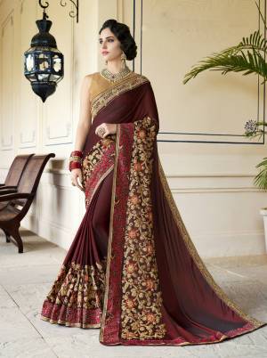 For A Royal Queen Look, Grab this Designer Saree In Maroon Color Paired With Beige Colored Blouse. This Saree Is Silk Based Fabric Beautified With Heavy Embroidery Over The Broad Border. Buy This Designer Saree Now.