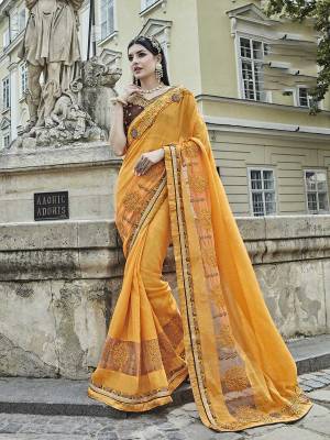 Celebrate This Festive Season Wearing This Designer Saree In Yellow Color Paired With Contrasting Brown Colored Blouse. This Saree Is Fabricated On Silk Chiffon Paired With Art Silk Fabricated Blouse. It Is Beautufied With Resham And Jari Embroidery. Buy Now.