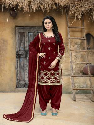 Enhance Your Personality Wearing This Designer Salwar Suit In Maroon Color. This Semi-Stitched Suit Has Art Silk Fabricated Top Paired With Santoon Bottom And Net Dupatta. It Is Beautified With Jari Embroidery and Mirror Work. Buy This Attractive Looking Suit Now.