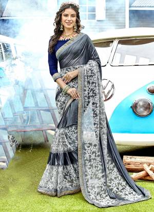 Flaunt Your Rich And Elegant Taste Wearing This Designer Saree In Dark Grey Color Paired With Contrasting Navy Blue Colored Blouse, This Saree Is Fabricated On Lycra And Net Paired With Art Silk Fabricated Blouse. It Has Pretty Attractive Embroidery Which Will earn You Lots Of Compliments From Onlookers.