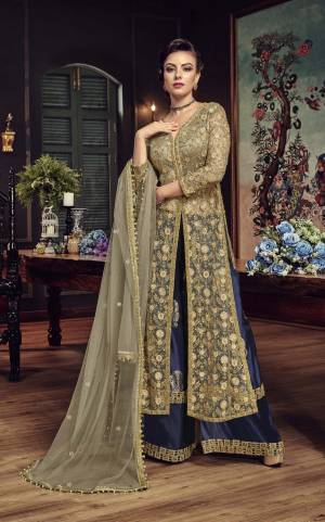 Get Ready For The Upcoming Wedding Season with This Heavy Designer Indo-Western Suit In Grey Colored Top Paired With Contrasting Navy Blue Colored Bottom And Grey Dupatta. Its Top And Dupatta Are Fabricated On Net Paired With Paper Silk Bottom. Buy Now.