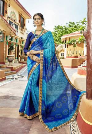 For Your Semi-Casual Wear Or Festive Wear, Grab This Beautiful Saree In Blue Color Paired With Navy Blue Colored Blouse. This Bandhej Saree Is Chiffon Based Paired With Art Silk Fabricated Blouse. Buy This Saree Now.