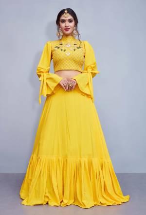 Here Is A Lovely Patterned Designer Lehenga Choli In Yellow Color. This Readymade Lehenga Choli Is Crepe Silk Based Fabric. It Blouse Has Very Pretty Attractive Embroidery With High Neck And Bell Sleeve Pattern. Buy Now.